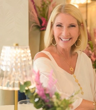 Lisa Jiménez, bestselling author and mindset coach, smiling in an elegant room