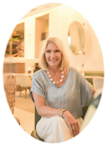 Lisa J., five-time bestselling author, seated and smiling in a bright elegant room
